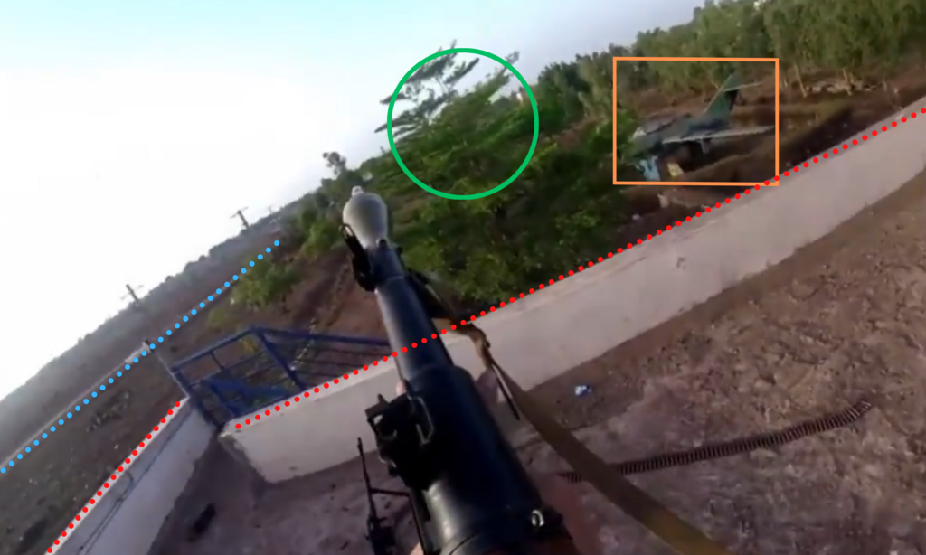 Le batîment, l'arbre et l'épave d'avion permettent de géolocaliser précisément la scène.