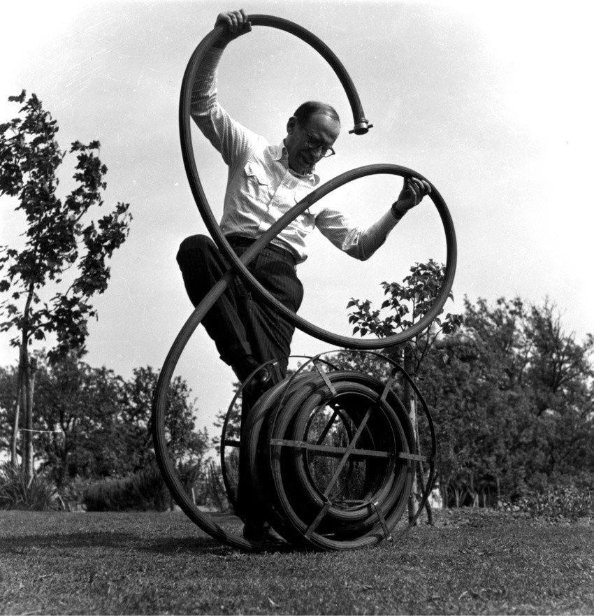 Lee Miller, [Saul] Steinberg se bat avec le tuyau d’arrosage d’une façon bien à lui, [Saul] Steinberg fights with the garden hose in a manner all his own, Jardins farleys, 1952,East Sussex, Chiddingly, Lee Miller Archives. © Lee Miller Archives, England 2026. All rights reserved 