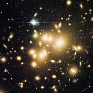 Un espace-temps à 5 dimensions est-il la clé des énigmes de la matière noire ? 3 La présence de la matière noire dans les amas galactiques peut être déduite de l'effet de lentille gravitationnelle forte qu'elle génère, comme sur cette image prise par Hubble de l'amas Abell 1689 montrant des arcs lumineux. Il se pourrait que la lumière soit déviée, ironiquement, parce que l'amas contient des photons noirs. © Nasa