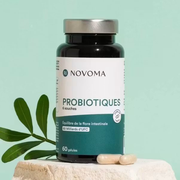 Flacon de probiotiques Novoma avec fond vert et feuille décorative.